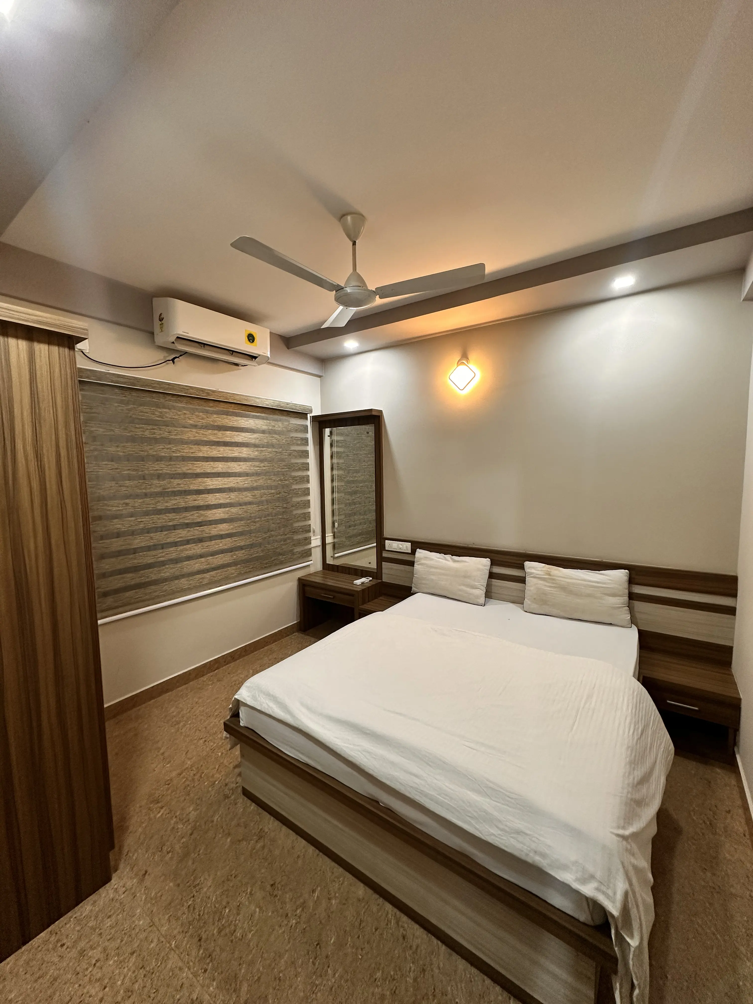 Queen size bed with white linen and wooden dresser